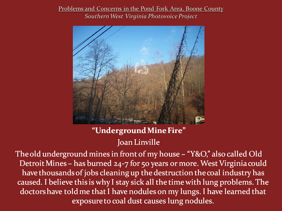 A wooded mountainside with a pale, exposed patch near the ridge, identified by the photographer as an underground mine fire.