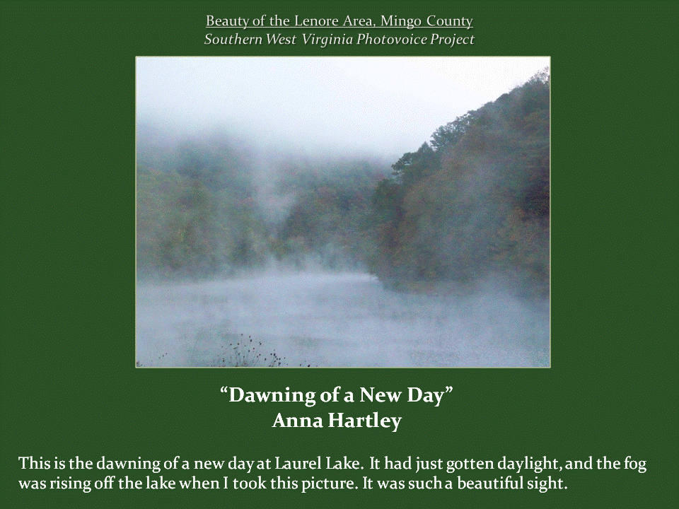 Early morning fog rises from the surface of Laurel Lake, partially obscuring the forested hills surrounding the water.