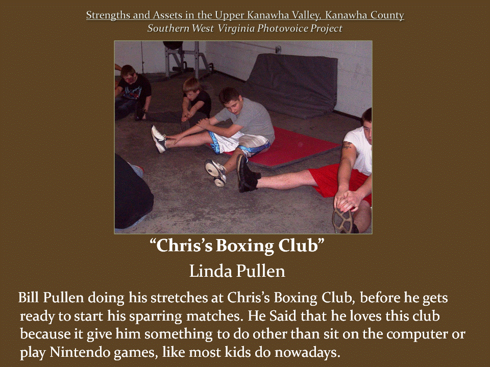 Four young people stretch on the floor of a boxing gym, sitting on exercise mats with their legs extended before training.