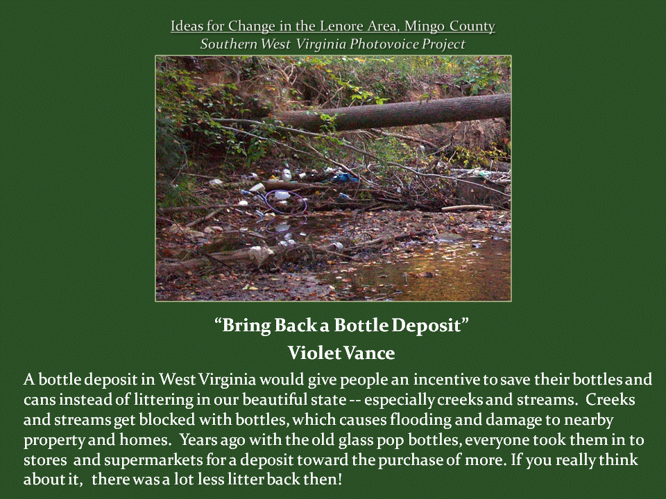 A shallow woodland creek cluttered with discarded bottles, cans, fallen branches, and other debris.
