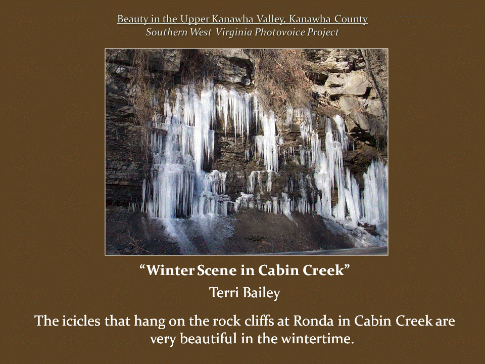 Long clusters of icicles hang from layered rock cliffs, forming frozen cascades against the dark stone surface.